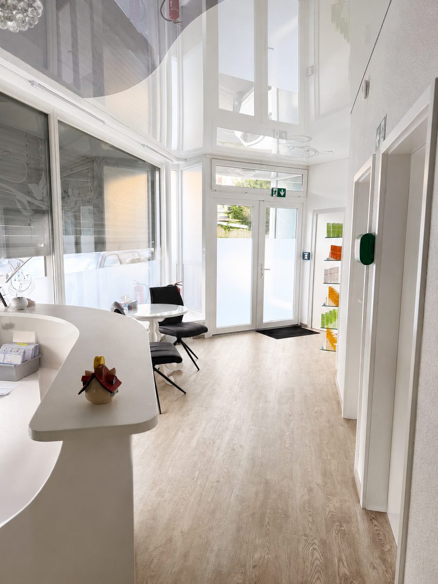 Heller Empfang mit Tresen, Sitzplatz und Blick zum Eingang